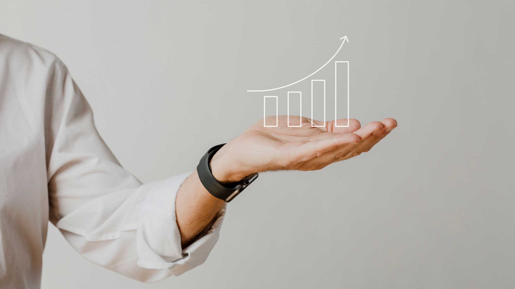 A person in a light-colored shirt holding an imaginary 3d growth chart with rising bars and an upward arrow, symbolizing progress or success, against a plain background.