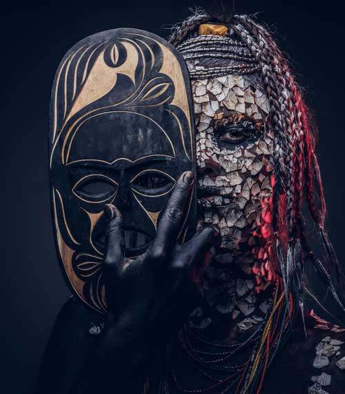 image of a man holding a mask with a black background.